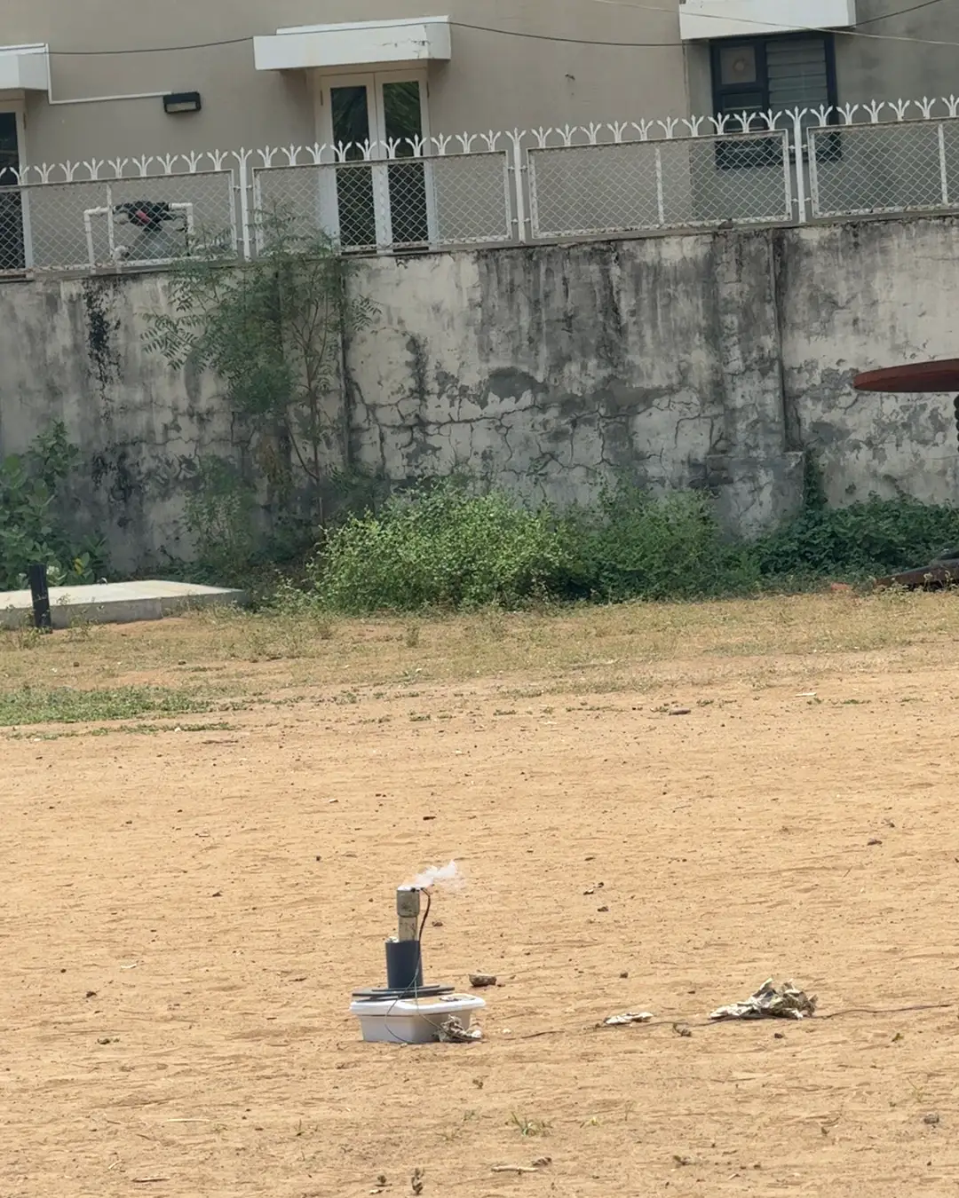 ISRA's T002 static fire: a motor on the thrust rig in an open field, firing a column of white exhaust.